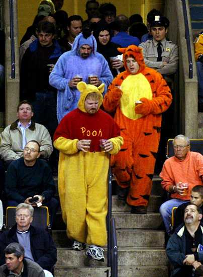 BRUINS FANS DRESSED AS WINNIE THE POOH AND TIGGER AND EEYORE CARRY BEERS BACK TO SEATS.